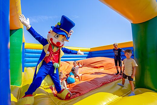 Mascot and children on inflatable game at CAPFUN Mille Pépites campsite in Carnon.