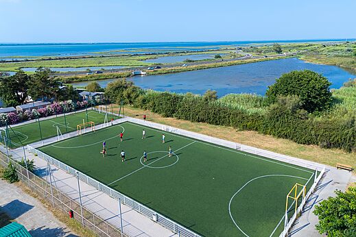 Synthetic multi-sport field with players, aerial view at CAPFUN Mille Pépites campsite in Carnon (34).