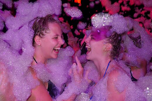 Lively foam party with young women laughing at CAPFUN Mille Pépites campsite in Carnon (34).