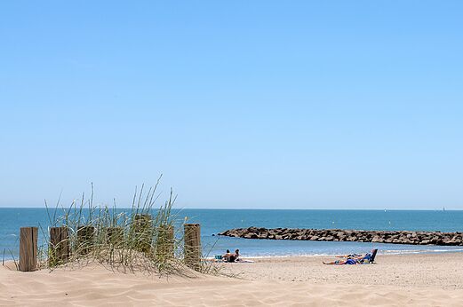 Sandy beach, sea and rocky breakwater at CAPFUN Mille Pépites campsite in Carnon (34).