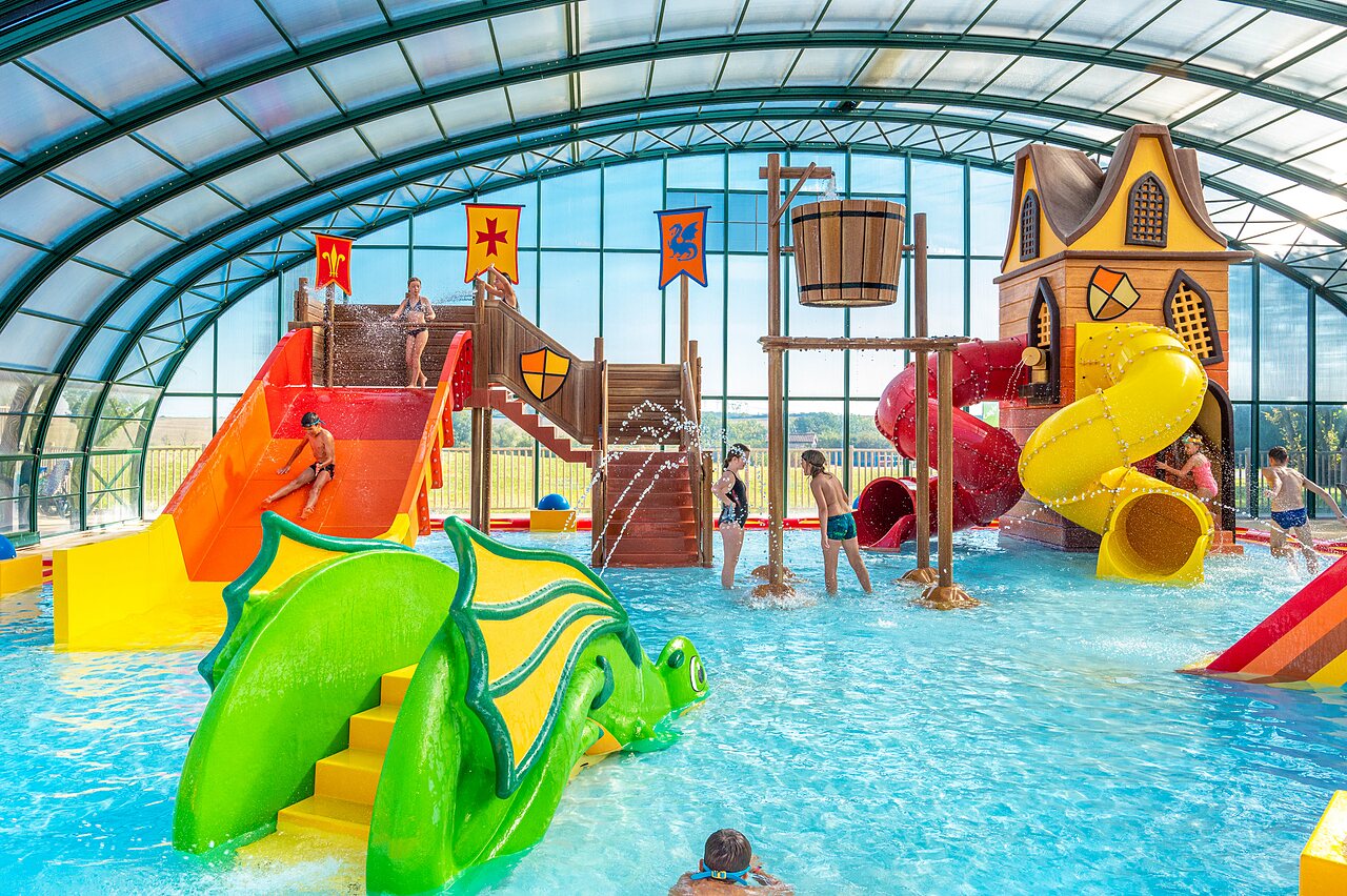 Indoor pool with slides, water games and children at CAPFUN Mirabelle campsite in VOLSTROFF (57).