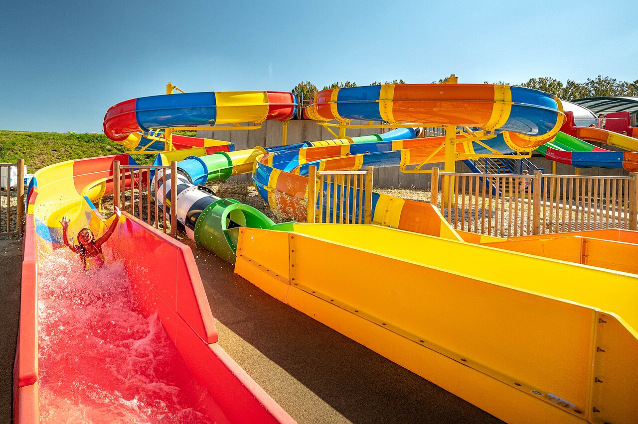 Colorful water slides and happy child at CAPFUN Mirabelle campsite in VOLSTROFF (57).
