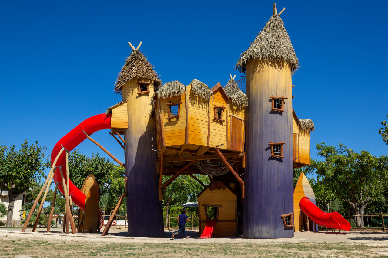 Large wooden play structure with red slides at CAPFUN Mirmanda campsite in Cambrils - Vinyols i els Arcs (43).