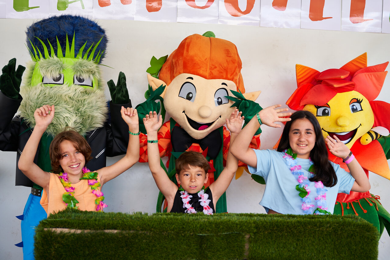 Smiling children with mascots for entertainment at CAPFUN Mirmanda campsite, Cambrils.