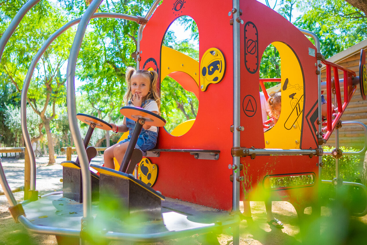 Child on colorful merry-go-round playground at CAPFUN Mirmanda campsite in Cambrils.