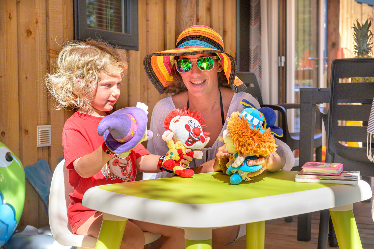 Child and woman play puppets at Mobil-home CAPFUN Mirmanda campsite in Cambrils.