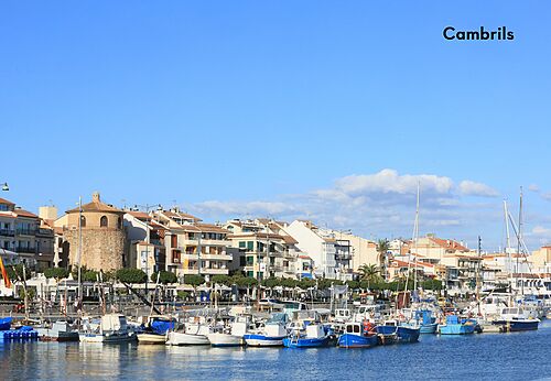 Port of Cambrils with boats and colorful buildings, a place to visit.