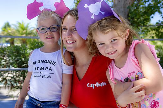 Capfun animator and smiling children with pirate hats at CAPFUN Mirmanda.
