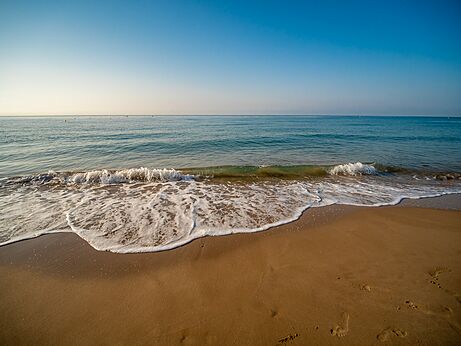 Fine sandy beach, gentle waves at CAPFUN Mirmanda campsite in Cambrils.