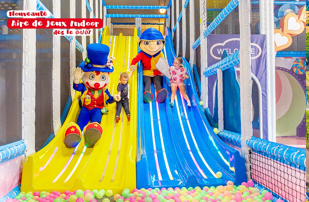 Indoor play area with slides, mascot and children at CAPFUN Montsabert campsite in COUTURES (49).