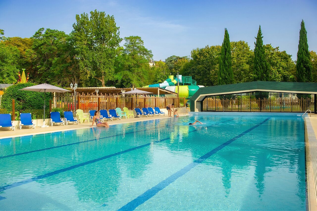 Large outdoor swimming pool with water slide and sun loungers at CAPFUN Montsabert campsite in COUTURES (49).