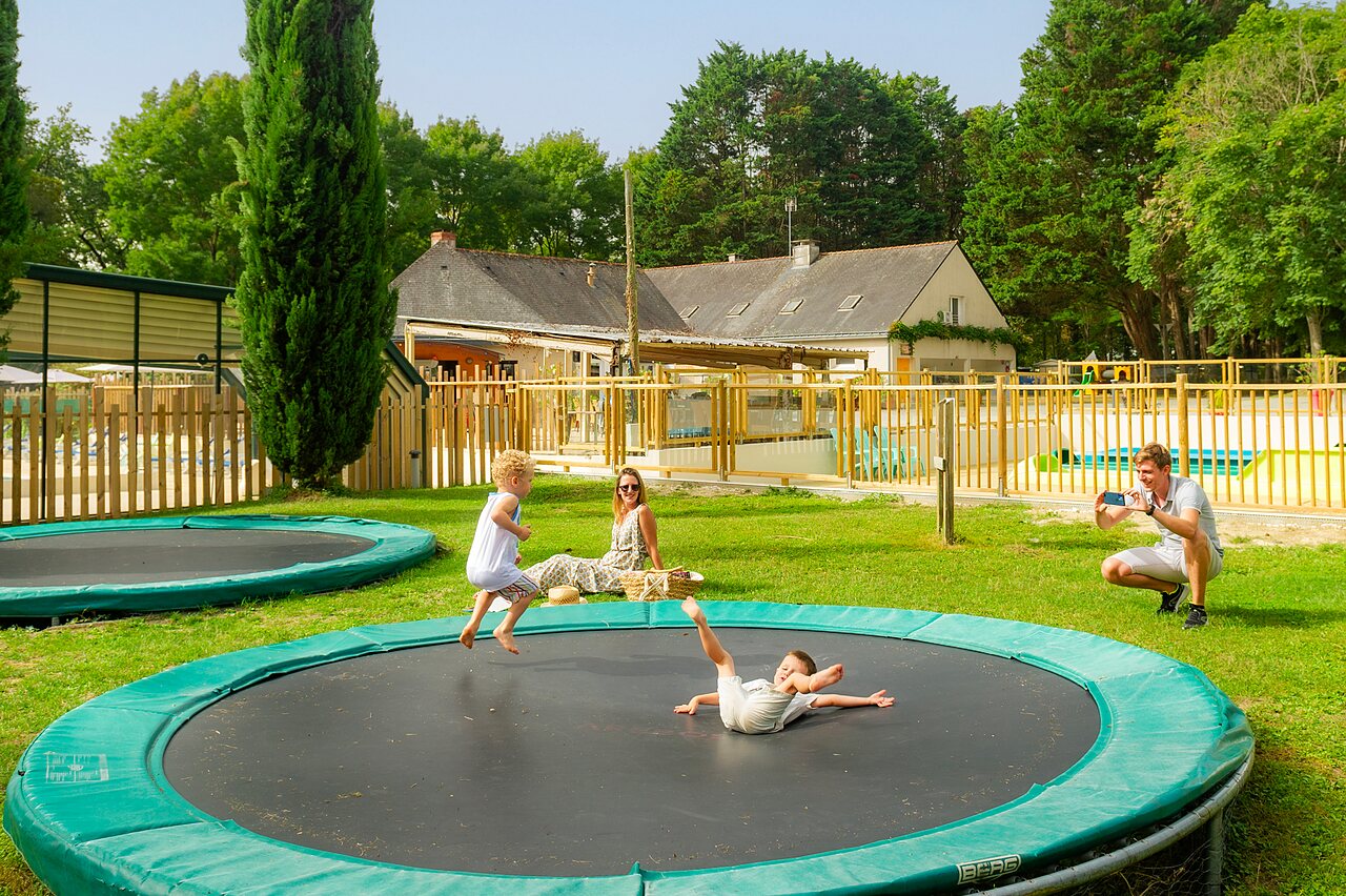 Children jumping on trampolines, nearby pool, CAPFUN Montsabert campsite, COUTURES (49).