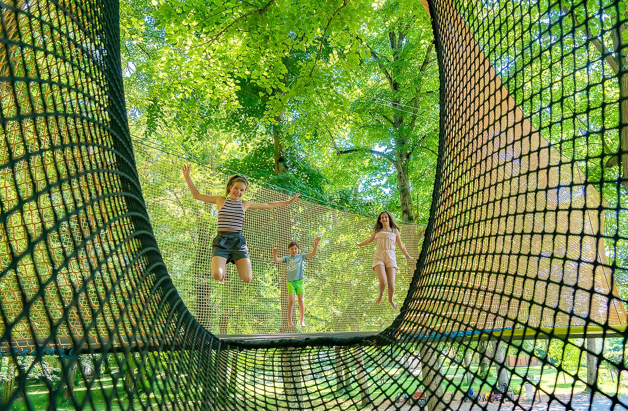 Children jumping on a giant play net at CAPFUN Montsabert campsite in COUTURES (49).