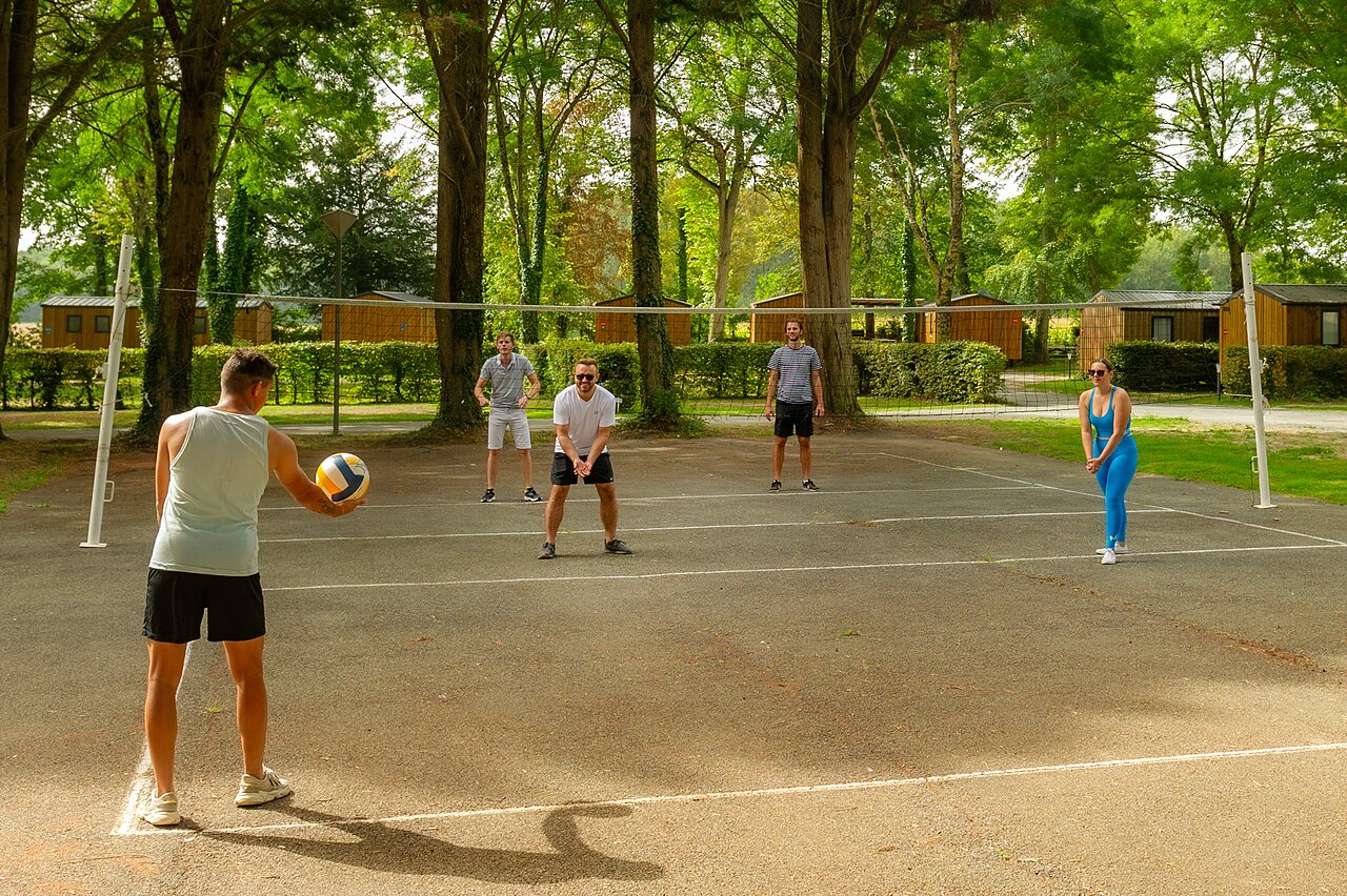 Volleyball court with players and Mobile-homes at CAPFUN Montsabert campsite COUTURES (49).