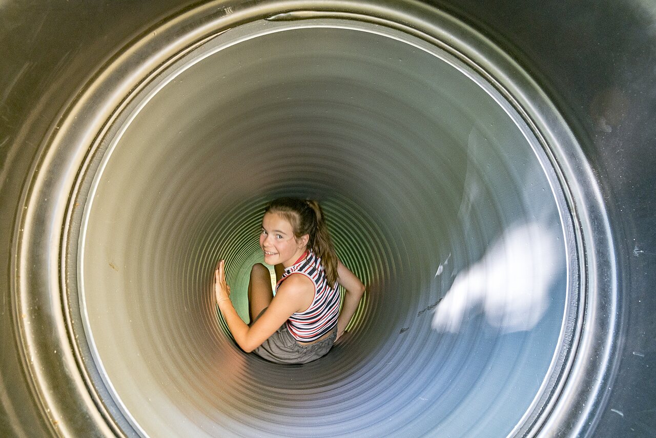 Smiling girl in tube slide at CAPFUN Montsabert campsite in COUTURES (49).