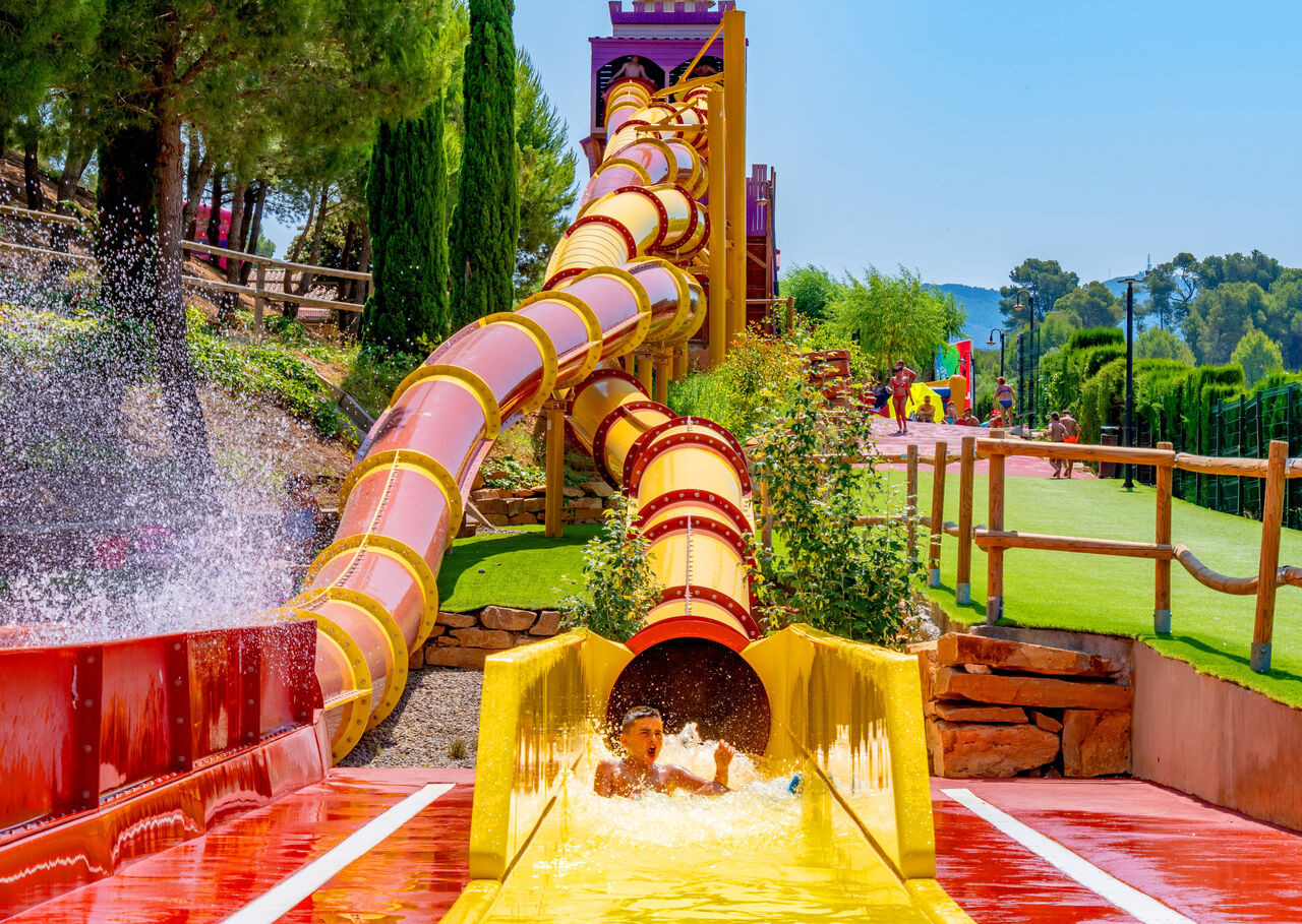 Giant water slide with child having fun, splashes at CAPFUN Montblanc Park campsite in Montblanc (43).