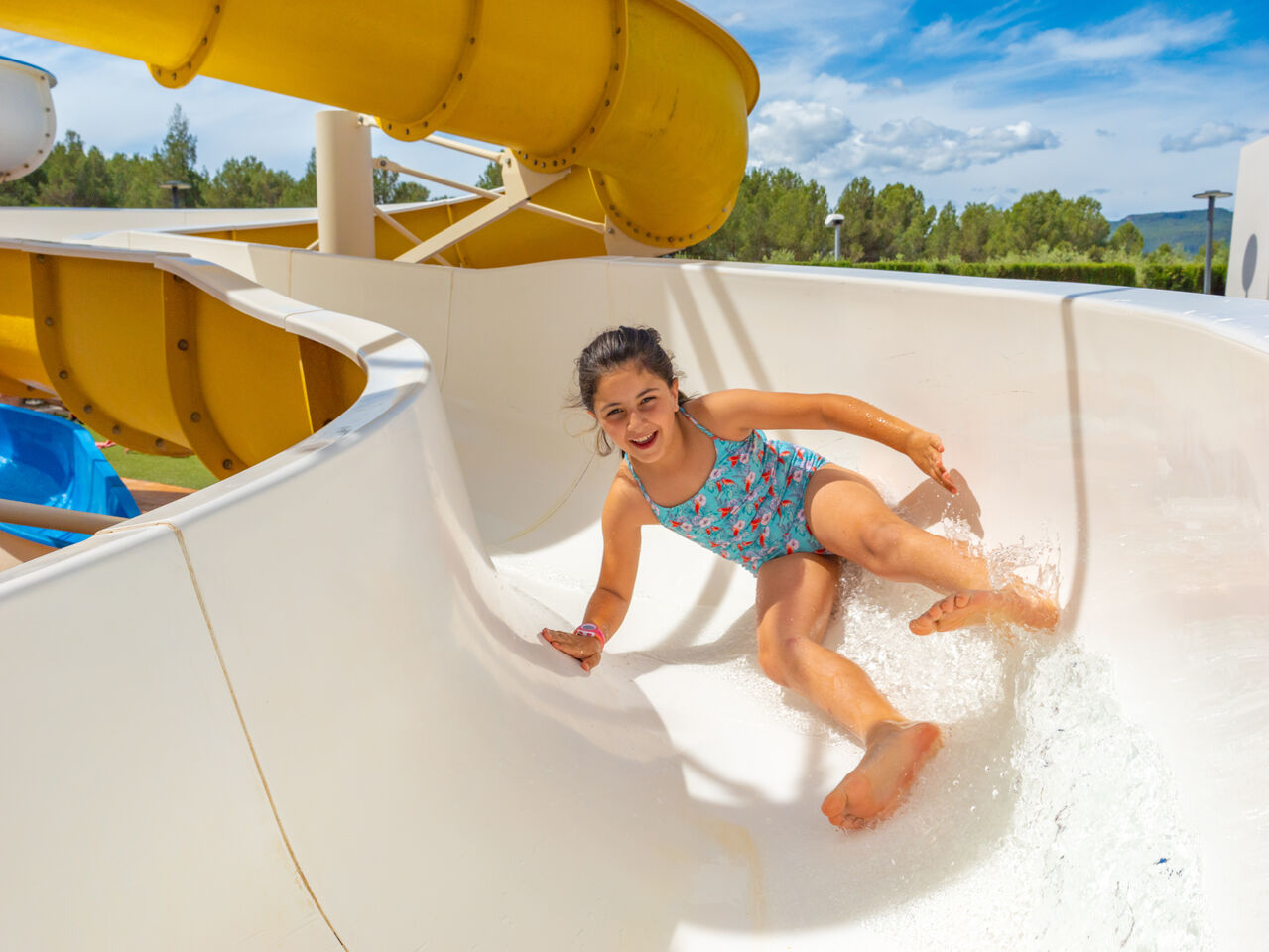 Smiling child on water slide at CAPFUN Montblanc Park campsite, Montblanc (43).