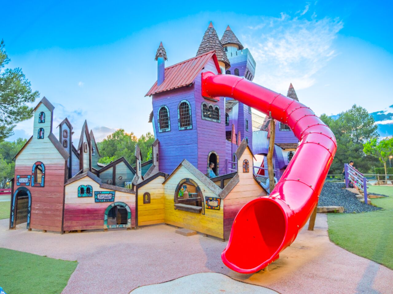 Colorful castle playground with large red slide at CAPFUN Montblanc Park campsite in Montblanc (43).