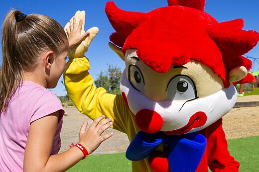 Child and Capfun mascot high-fiving at CAPFUN Montblanc Park campsite in Montblanc (43).