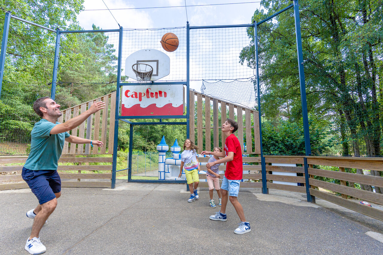 Basketball court with family playing at CAPFUN Moulinal campsite in BIRON (24).
