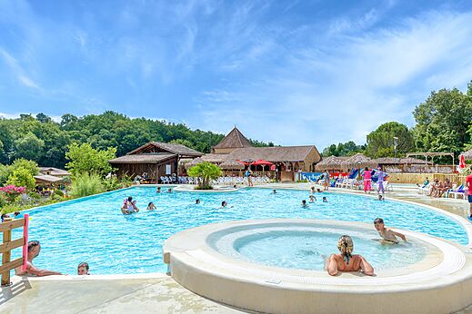 Large outdoor swimming pool with jacuzzi and swimmers at CAPFUN Moulinal campsite in BIRON (24).