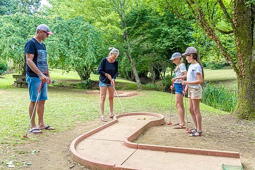 Family playing mini-golf on the course at CAPFUN Moulinal campsite in BIRON (24).
