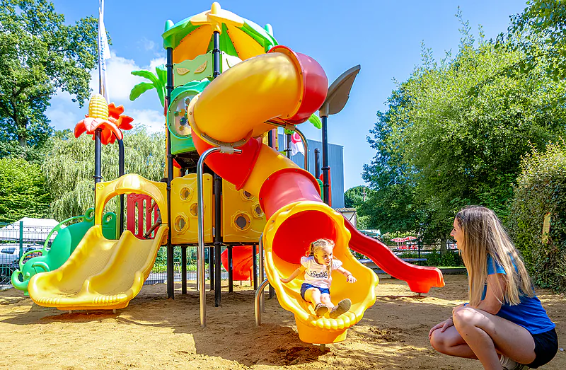 Colorful playground with slides and child at VAGUES OCEANES Moulin de Cadillac campsite in Noyal-Muzillac (56).