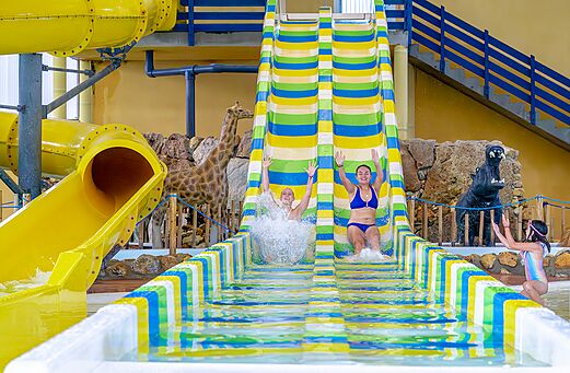 Colorful water slides and swimmers at VAGUES OCEANES Moulin de Cadillac campsite (56).