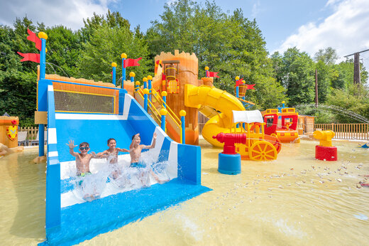 Aquatic playground with slides and children at CLICOCHIC Moulin du Roch campsite in Saint Andre D'Allas.