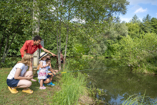 Family fishing in the pond at camping CLICOCHIC Moulin du Roch in Saint Andre D'Allas.