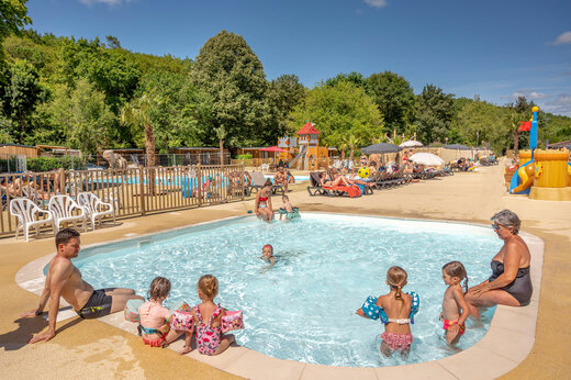 Outdoor swimming pool and water games at CLICOCHIC Moulin du Roch campsite in Saint Andre D'Allas.