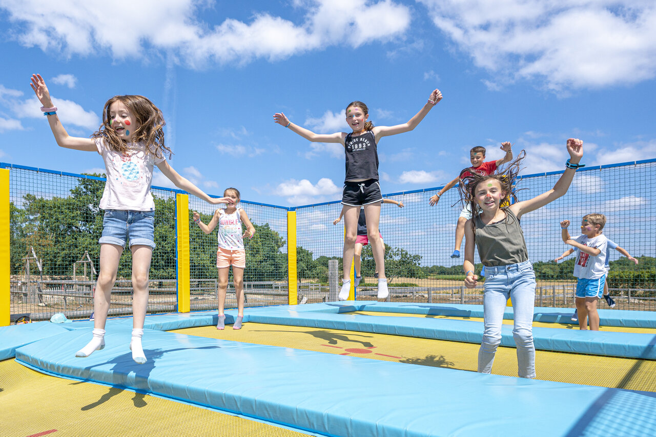 Children jumping on giant trampolines at VAGUES OCEANES Moustoir campsite in Carnac (56).
