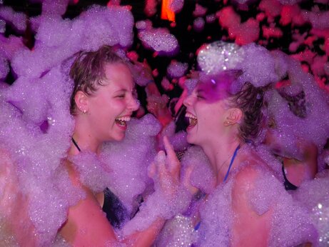 Lively foam party, laughing young women at VAGUES OCEANES Moustoir campsite in Carnac (56).