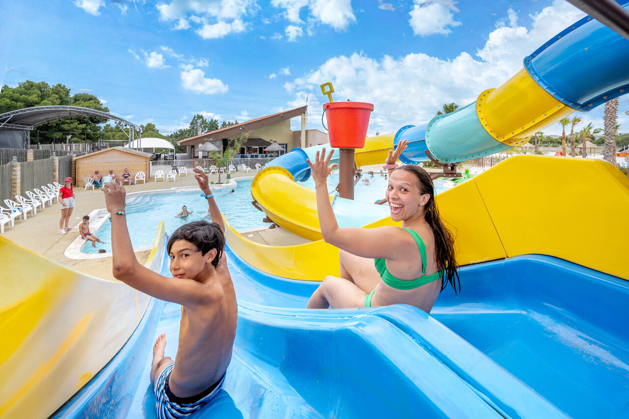 Colorful water slides and pool with giant bucket at CAPFUN La Nautique campsite in Narbonne (11).