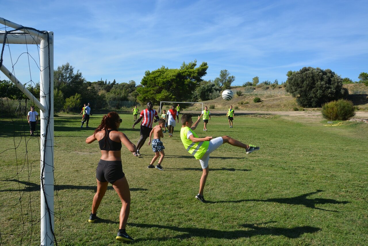 Football match on grassy sports field at CAPFUN La Nautique campsite.