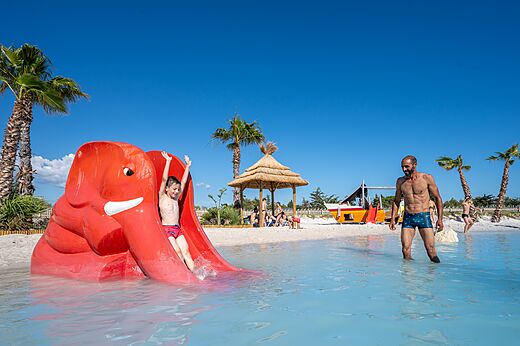 Red elephant slide and water games at CAPFUN La Nautique campsite in Narbonne (11).