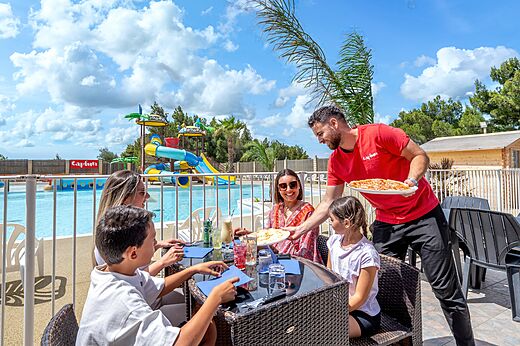 Outdoor restaurant with family, swimming pool, at CAPFUN La Nautique campsite in Narbonne.