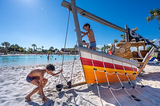 Pirate ship playground and lagoon pool at CAPFUN La Nautique campsite in Narbonne.