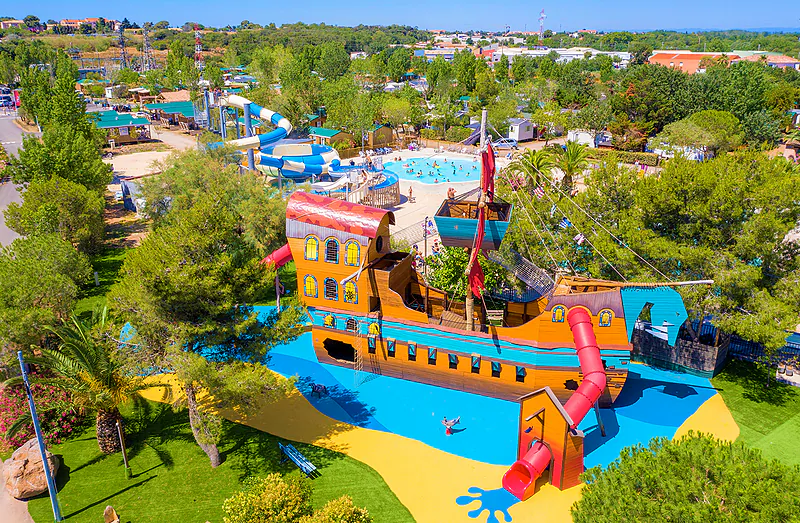 Pirate ship playground, swimming pool, water slides at CAPFUN La Nina campsite Agde (34).