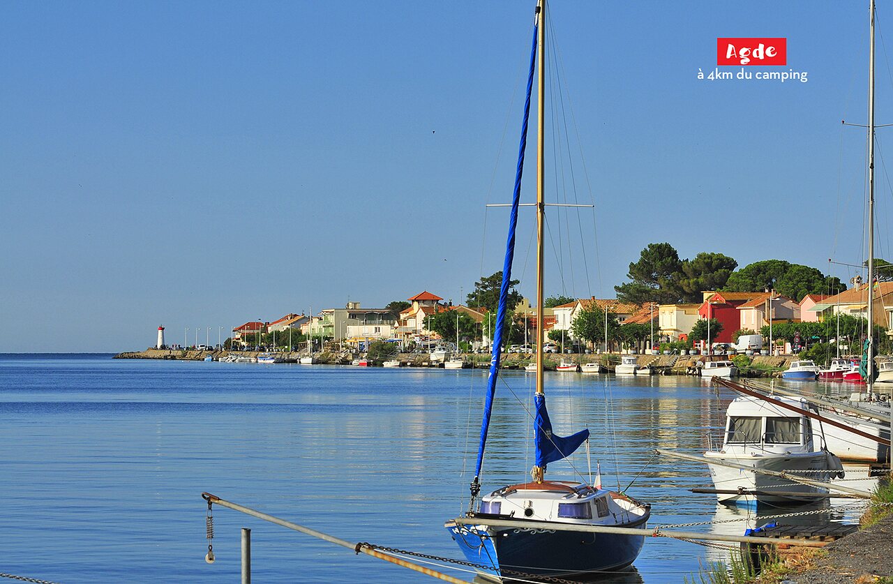 Port of Agde with boats and colorful houses, a place to visit near the campsite.