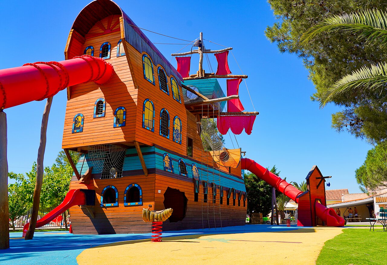 Giant pirate ship playground, red slides at CAPFUN La Nina campsite in Agde.