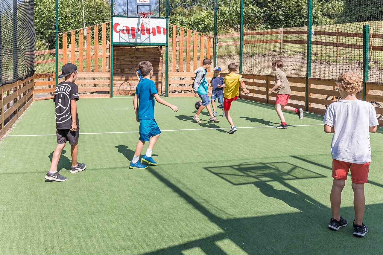 Children playing football on Capfun multisport field at CAPFUN La Nina in Agde (34).