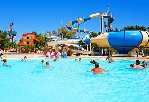 Outdoor swimming pool with water slides and play structures at CAPFUN La Nina campsite in Agde (34).