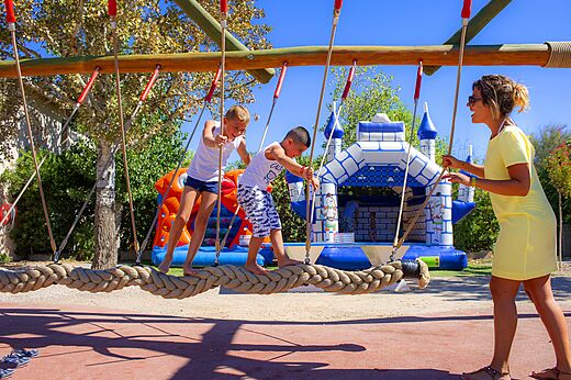 Children on rope bridge and bouncy castles, CAPFUN La Nina campsite Agde.