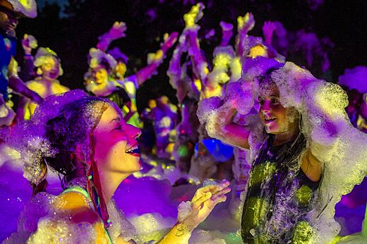 Smiling holidaymakers enjoying foam party at CAPFUN La Nina campsite, Agde (34).