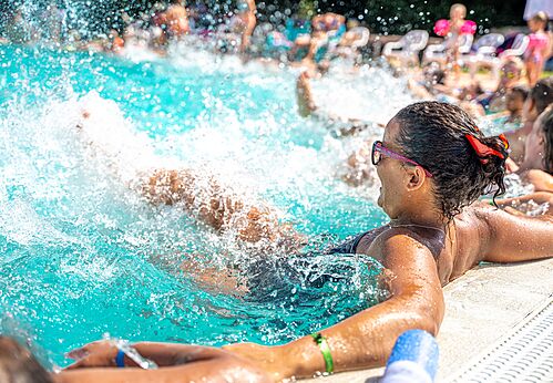 Woman relaxing in the swimming pool with water jets at CAPFUN La Nina campsite in Agde (34).