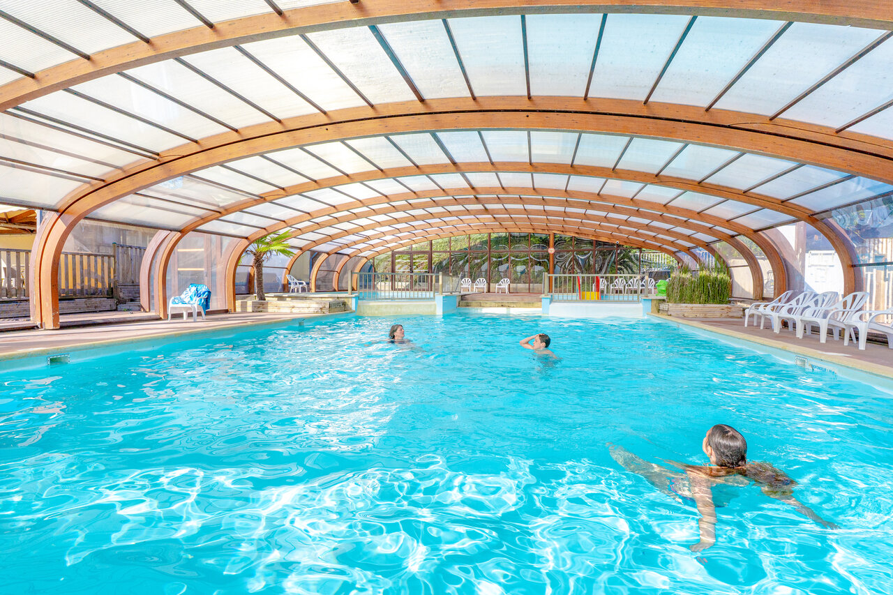 Heated indoor pool, swimmers, at VAGUES OCEANES Odyss�e campsite in Villers-sur-Mer.