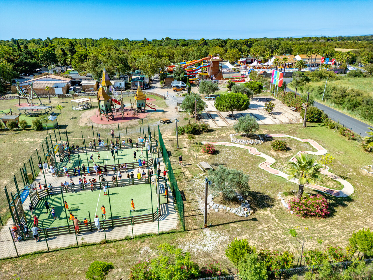 Multisport court with players, playground, mini-golf at CAPFUN Ondines campsite in Vias Plage (34).