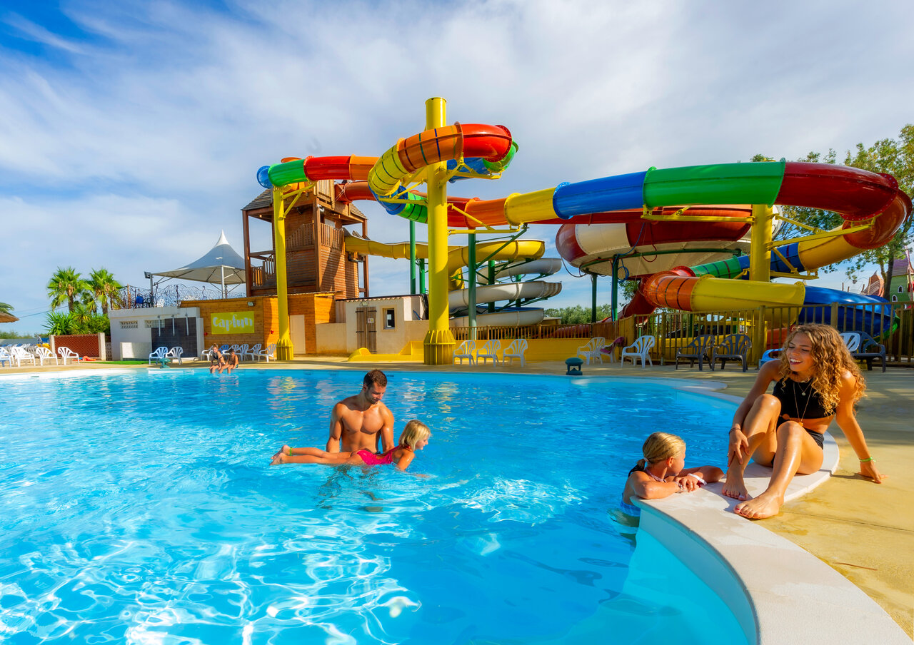 Outdoor swimming pool, colorful water slides, family at CAPFUN Ondines campsite in Vias Plage (34).