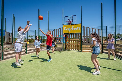 Multisport court with young people playing basketball at CAPFUN Ondines campsite in Vias Plage (34).